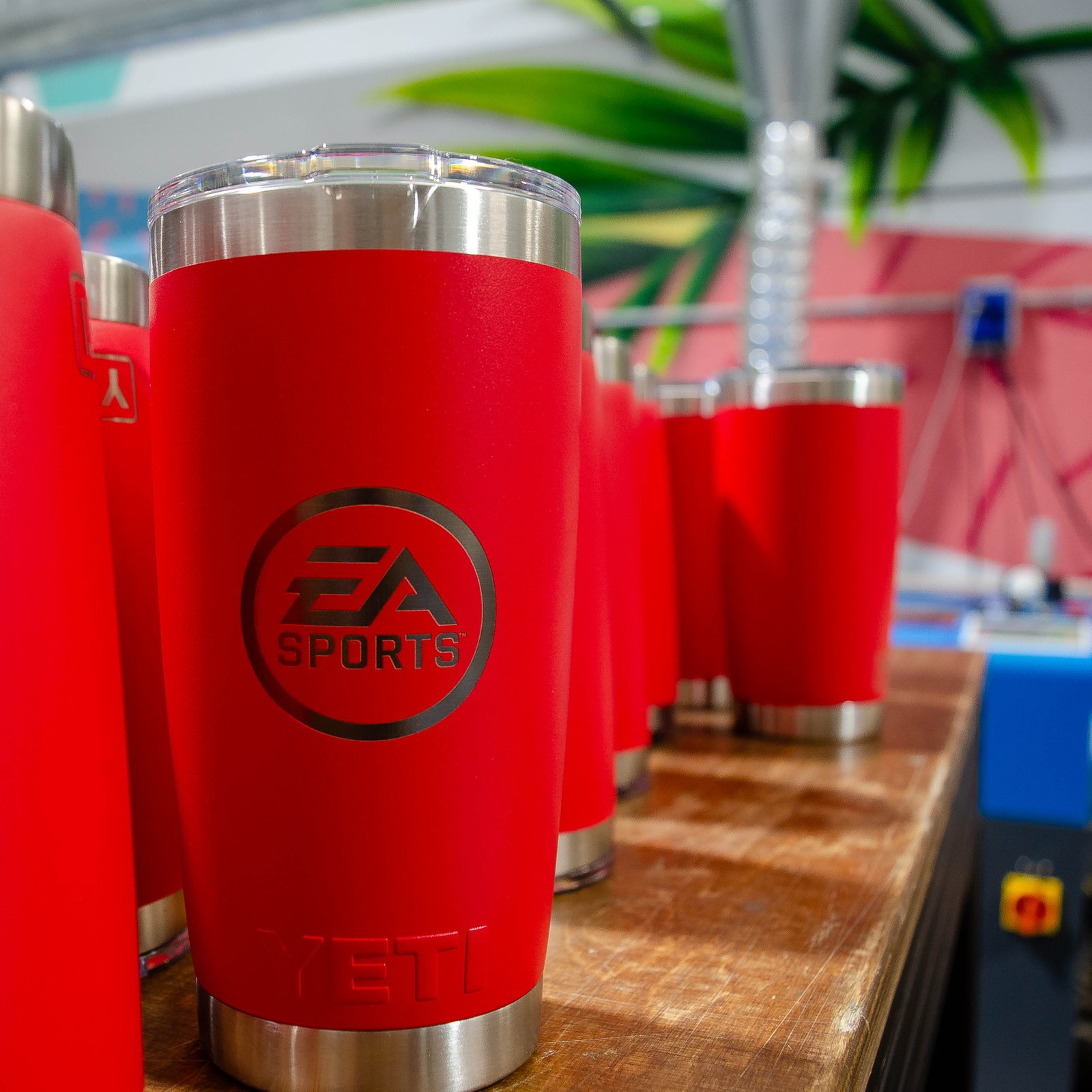 Vasos térmicos YETI con grabado del logotipo EA Sports alineados en la máquina láser, IDEÁTICA Madrid