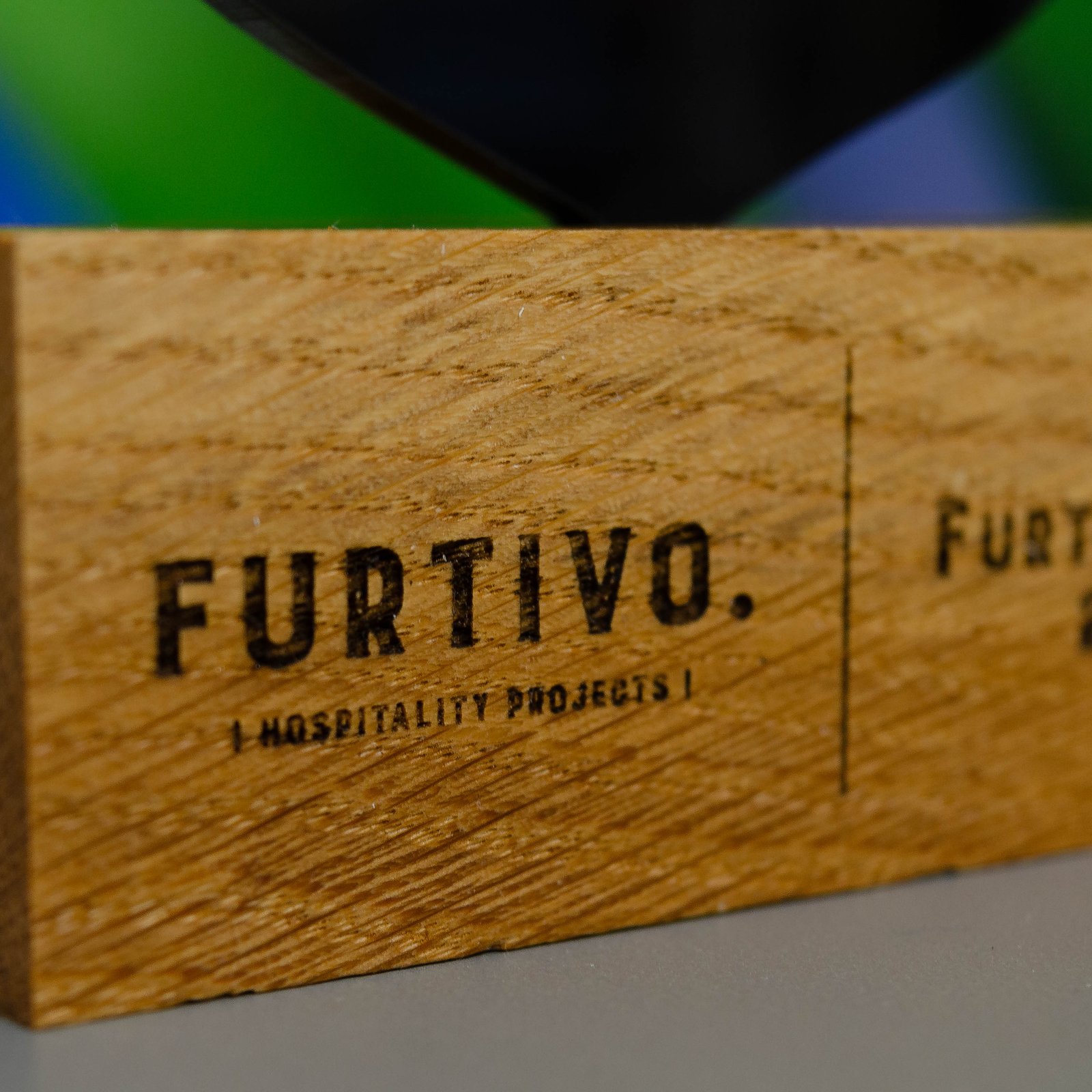 Detalle de la base de roble del trofeo FurtiAwards con grabado láser del logotipo FURTIVO Hospitality Projects
